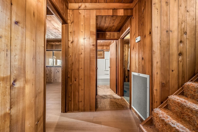 hallway featuring light hardwood / wood-style flooring, wooden ceiling, and wood walls