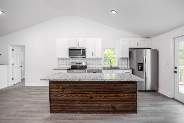 kitchen with white cabinetry, sink, stainless steel appliances, and a kitchen island