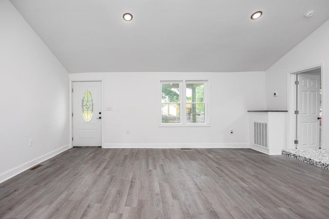 unfurnished living room featuring lofted ceiling and hardwood / wood-style floors