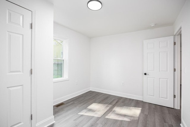 unfurnished room with wood-type flooring