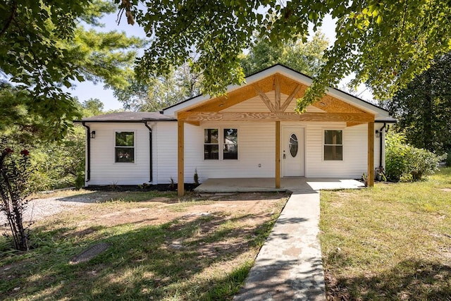 view of front of home with a patio and a front yard