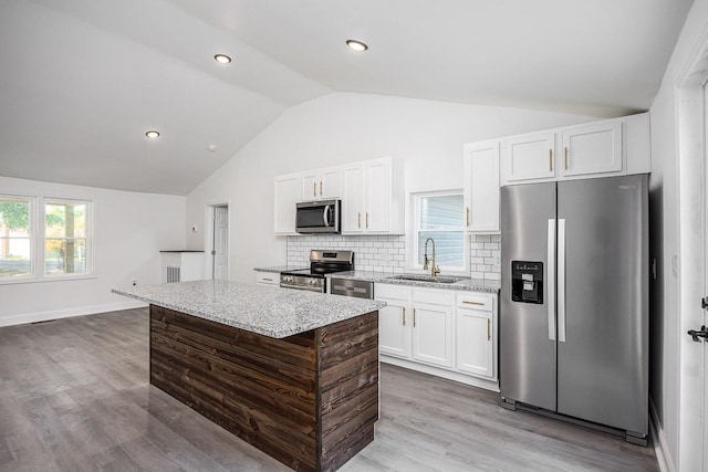 kitchen featuring sink, stainless steel appliances, a center island, and white cabinets