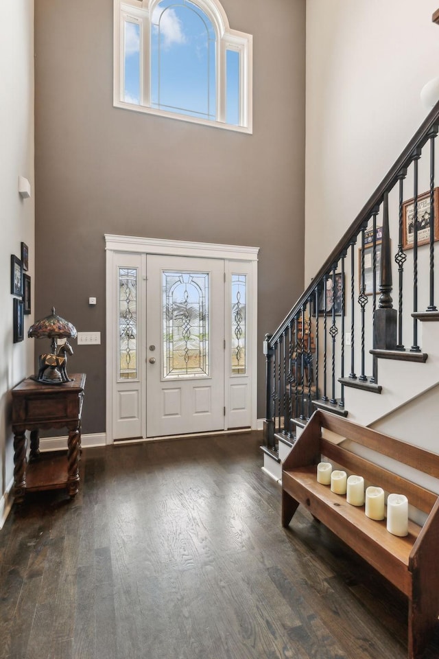 entryway with hardwood / wood-style floors and a towering ceiling