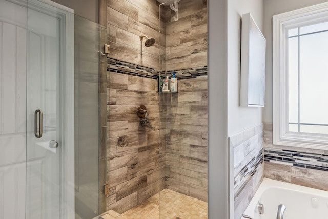 bathroom featuring shower with separate bathtub