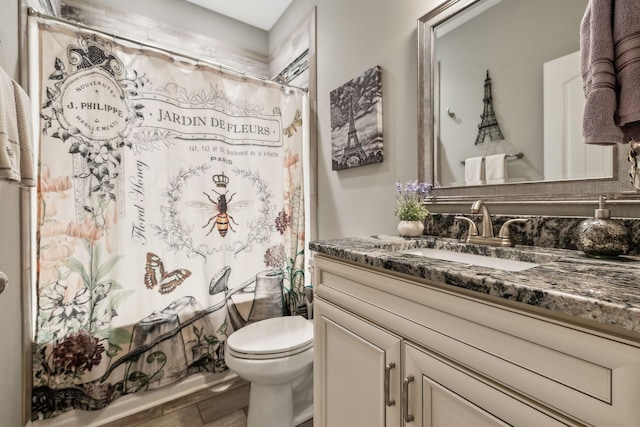 full bathroom with shower / tub combo with curtain, vanity, toilet, and hardwood / wood-style floors