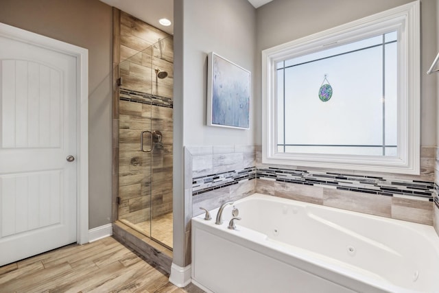 bathroom featuring wood-type flooring and shower with separate bathtub