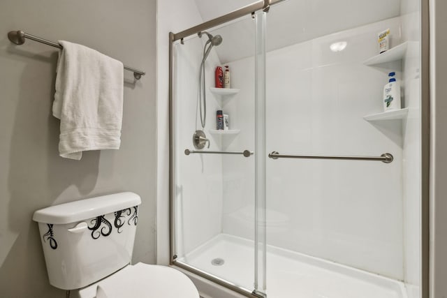 bathroom with toilet and a shower with shower door