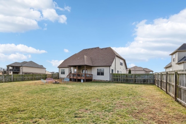 rear view of property with a wooden deck and a lawn