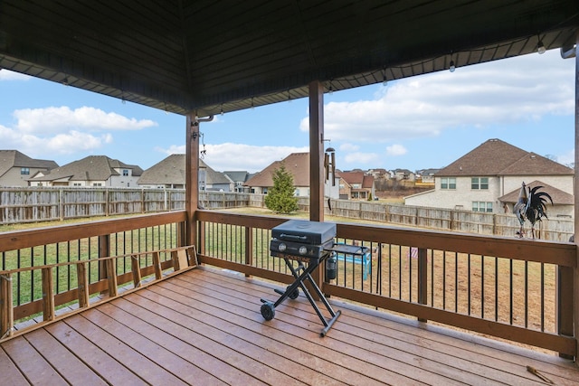 wooden terrace featuring grilling area and a lawn