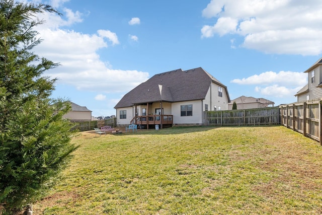 back of property with a wooden deck and a lawn