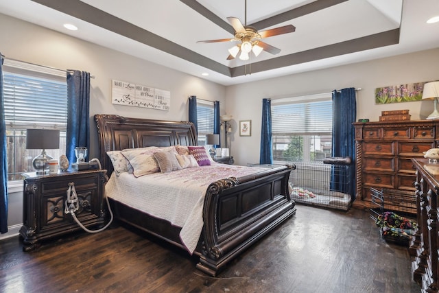 bedroom featuring ceiling fan, dark hardwood / wood-style floors, and a raised ceiling