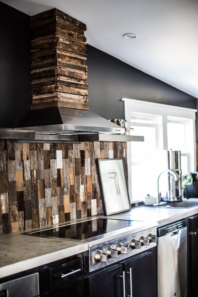 kitchen with sink, vaulted ceiling, gas cooktop, stainless steel dishwasher, and wall chimney range hood