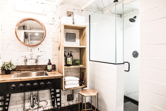 bathroom with a shower with door and sink