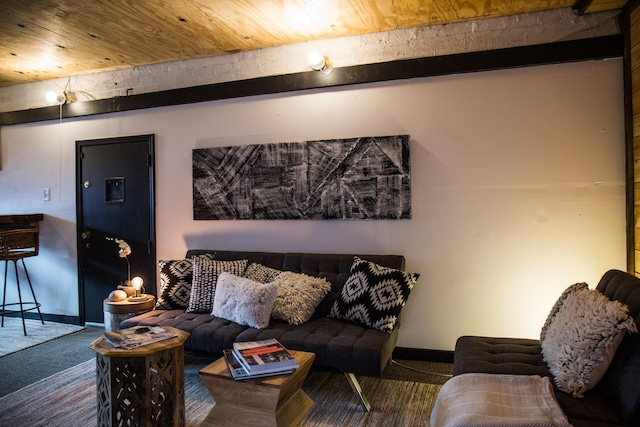 living room featuring beamed ceiling, carpet, and wooden ceiling