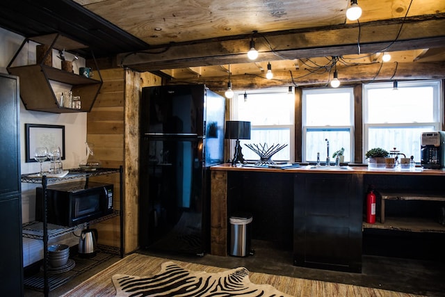 kitchen featuring beam ceiling, sink, and black appliances