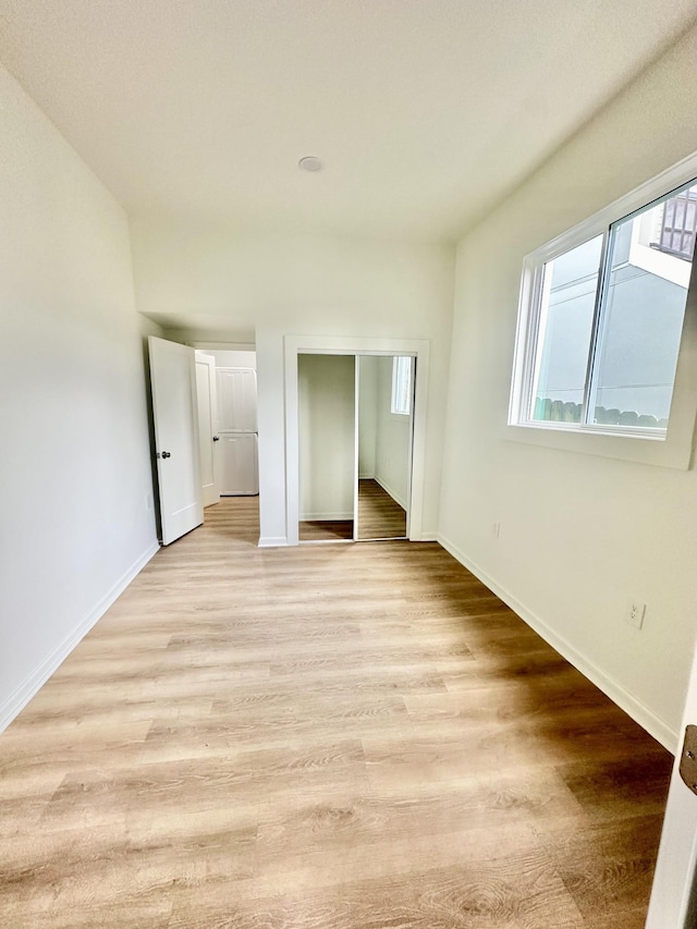 unfurnished bedroom featuring light hardwood / wood-style flooring and a closet