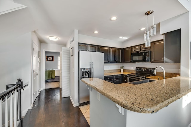 kitchen with pendant lighting, kitchen peninsula, sink, and black appliances