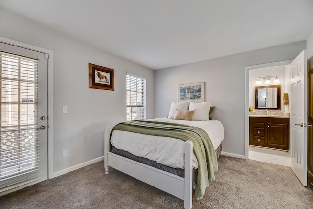 carpeted bedroom with ensuite bath and sink