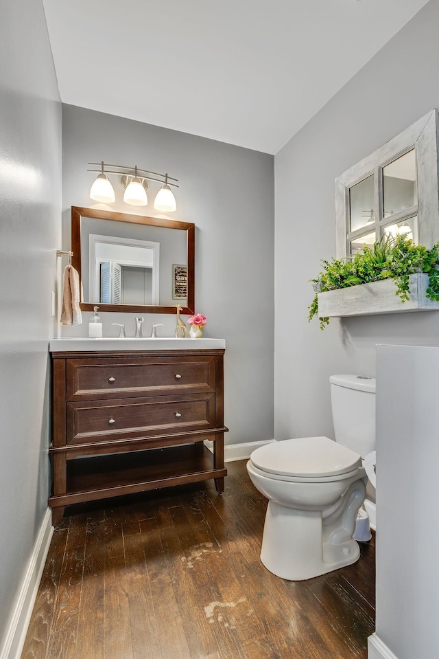 bathroom with vanity, wood-type flooring, and toilet