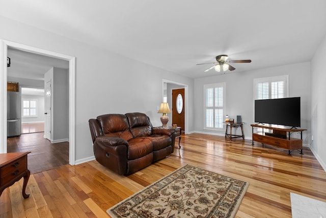 living room featuring wood-type flooring and ceiling fan