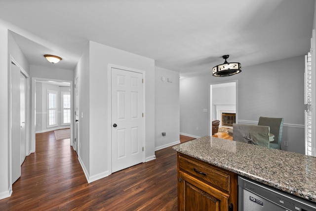 kitchen featuring dishwasher, dark hardwood / wood-style floors, and light stone counters