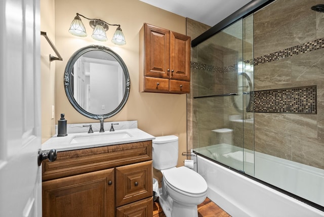 full bathroom featuring vanity, shower / bath combination with glass door, and toilet