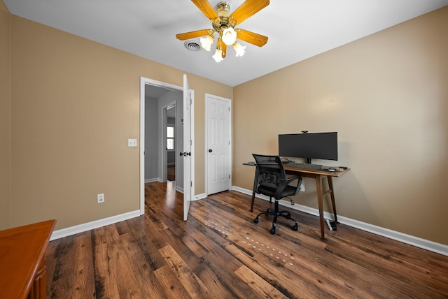 home office with dark wood-type flooring and ceiling fan