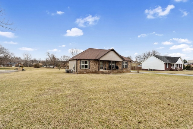 view of front of house with central AC unit and a front yard