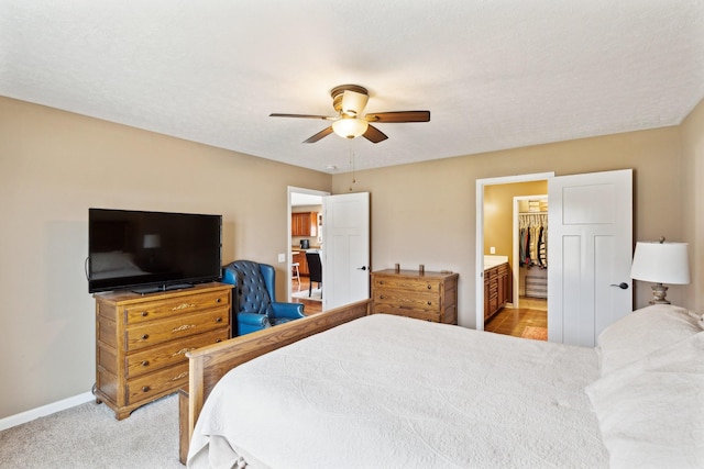 carpeted bedroom with ceiling fan and ensuite bath