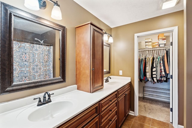 bathroom with vanity, tile patterned flooring, and a textured ceiling