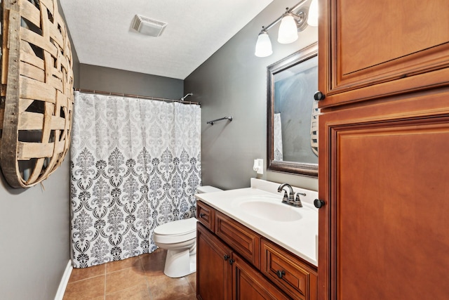 bathroom featuring tile patterned flooring, vanity, a textured ceiling, and toilet