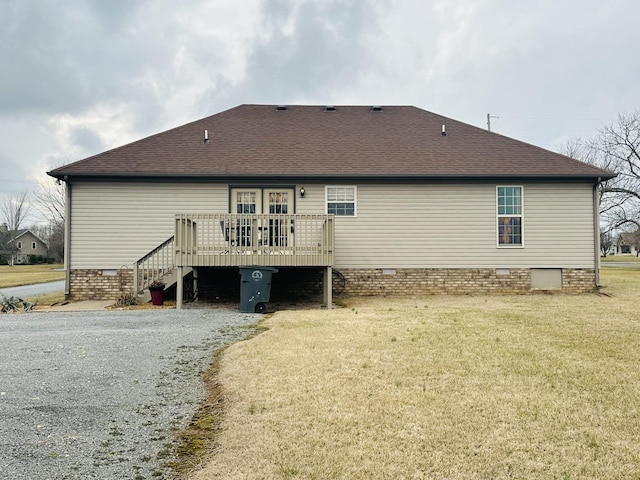 rear view of house with a wooden deck and a lawn