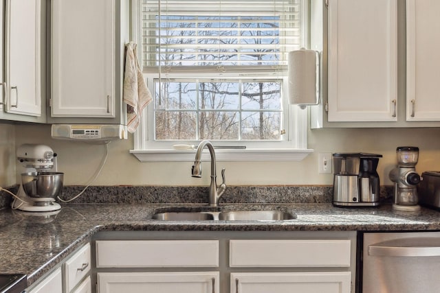 kitchen featuring white cabinetry, range, and sink