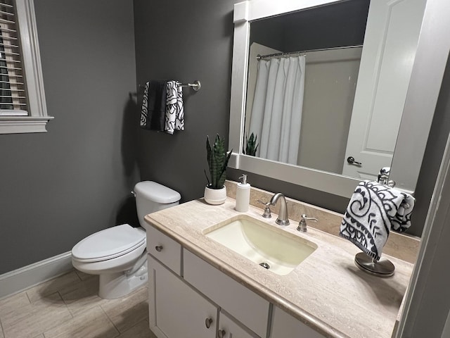 bathroom with walk in shower, vanity, and toilet