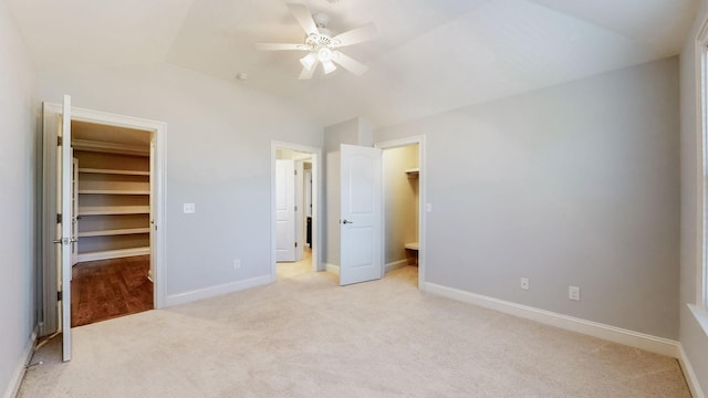 unfurnished bedroom featuring a walk in closet, light colored carpet, and a closet