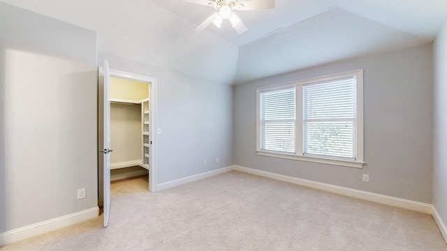 empty room with lofted ceiling, light colored carpet, and ceiling fan