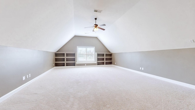 additional living space featuring vaulted ceiling, carpet, and built in features