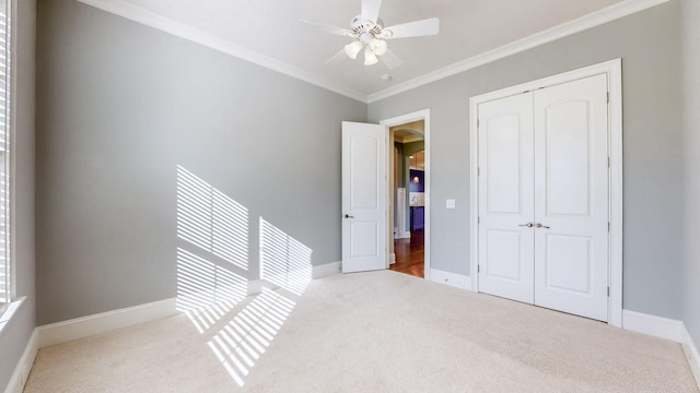 unfurnished bedroom with multiple windows, ornamental molding, light colored carpet, and a closet