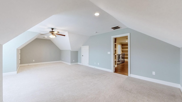 additional living space with vaulted ceiling, light carpet, and ceiling fan