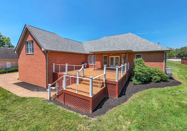 back of house featuring a wooden deck, a yard, and french doors