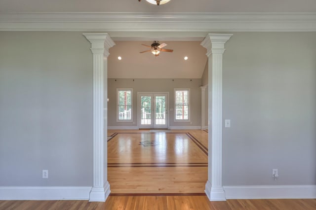 empty room featuring vaulted ceiling, ceiling fan, decorative columns, and light hardwood / wood-style flooring