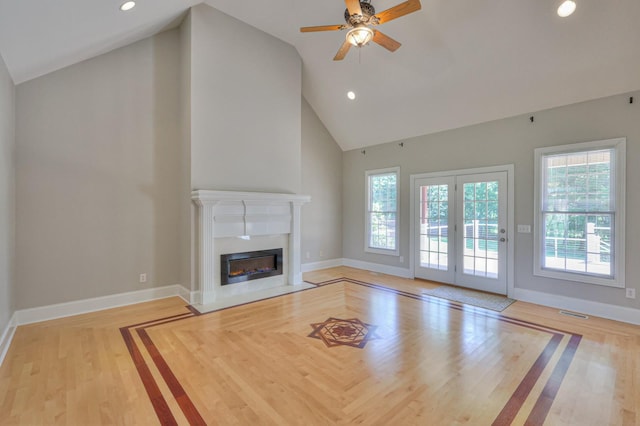 unfurnished living room featuring high vaulted ceiling, ceiling fan, and light hardwood / wood-style flooring