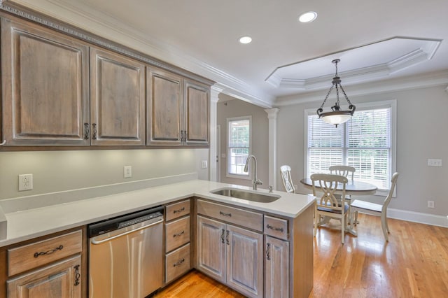 kitchen with decorative light fixtures, sink, stainless steel dishwasher, kitchen peninsula, and a raised ceiling