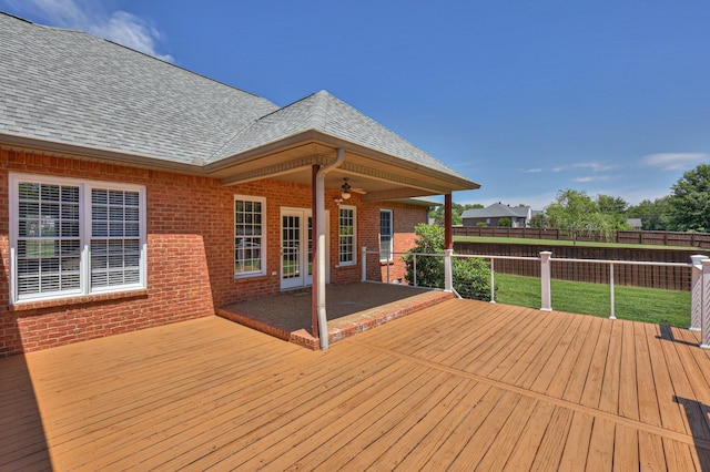 wooden terrace with ceiling fan, a yard, and a patio