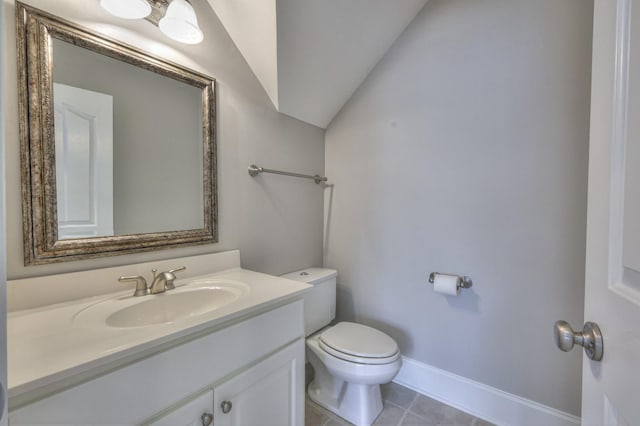 bathroom with vaulted ceiling, vanity, toilet, and tile patterned flooring