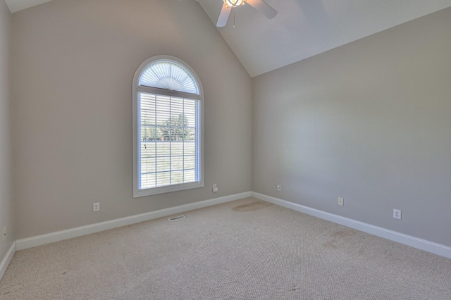 carpeted spare room featuring vaulted ceiling and ceiling fan