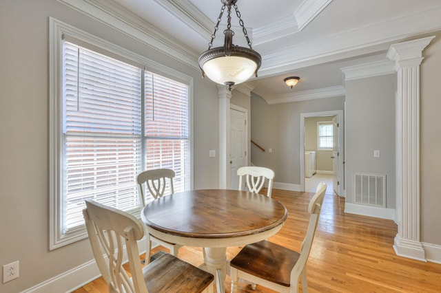 dining space with ornate columns, ornamental molding, light wood-type flooring, and washer / clothes dryer