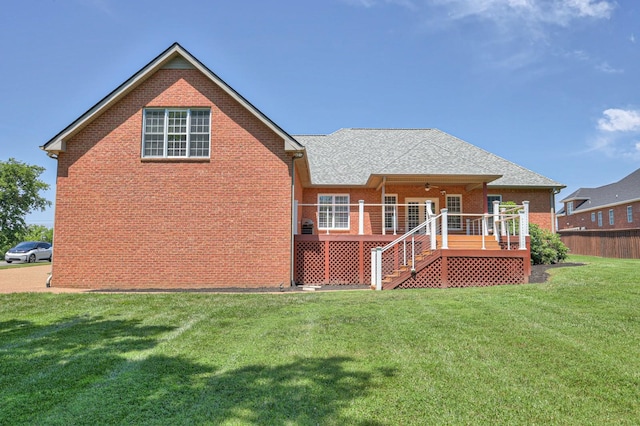 rear view of property with a wooden deck and a yard