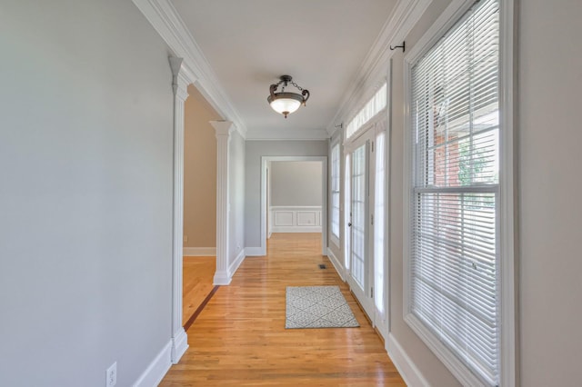 hallway with crown molding, light hardwood / wood-style floors, french doors, and ornate columns