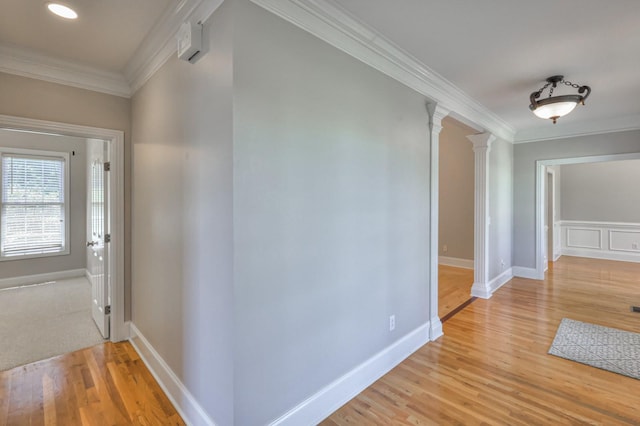 corridor with crown molding, hardwood / wood-style floors, and ornate columns